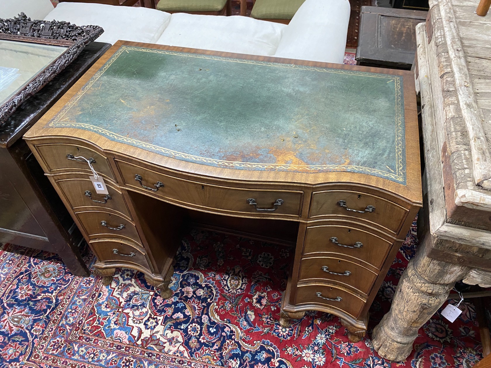 A reproduction George III style mahogany serpentine shaped kneehole desk, length 97cm, width 55cm, height 76cm